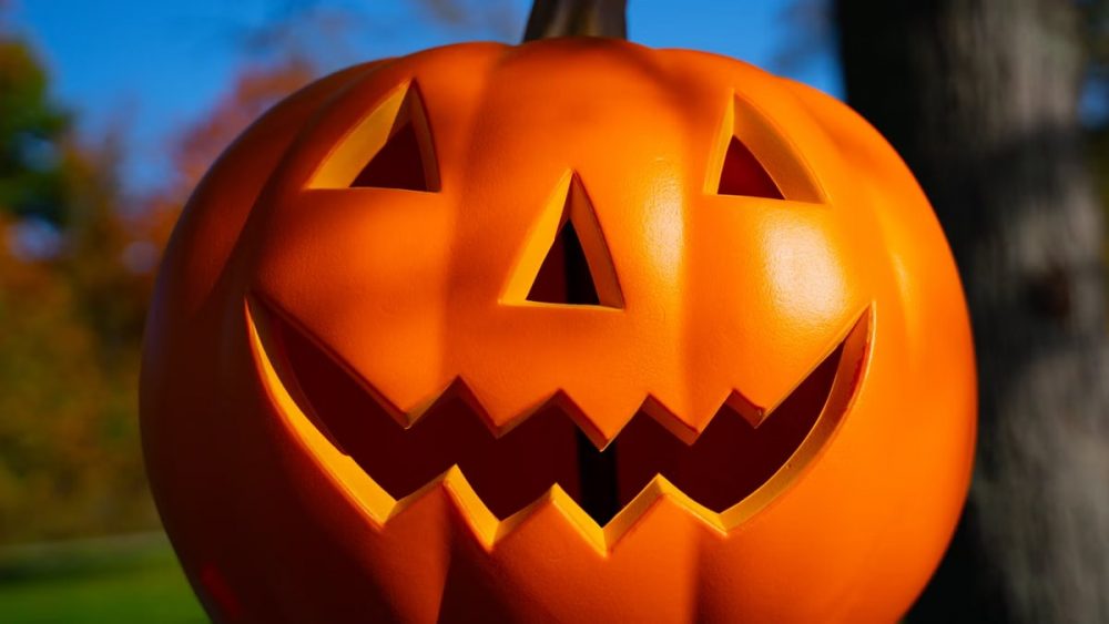 Brightly colored Jack-O'-Lantern with a spooky grin outdoors, perfect for Halloween themes.